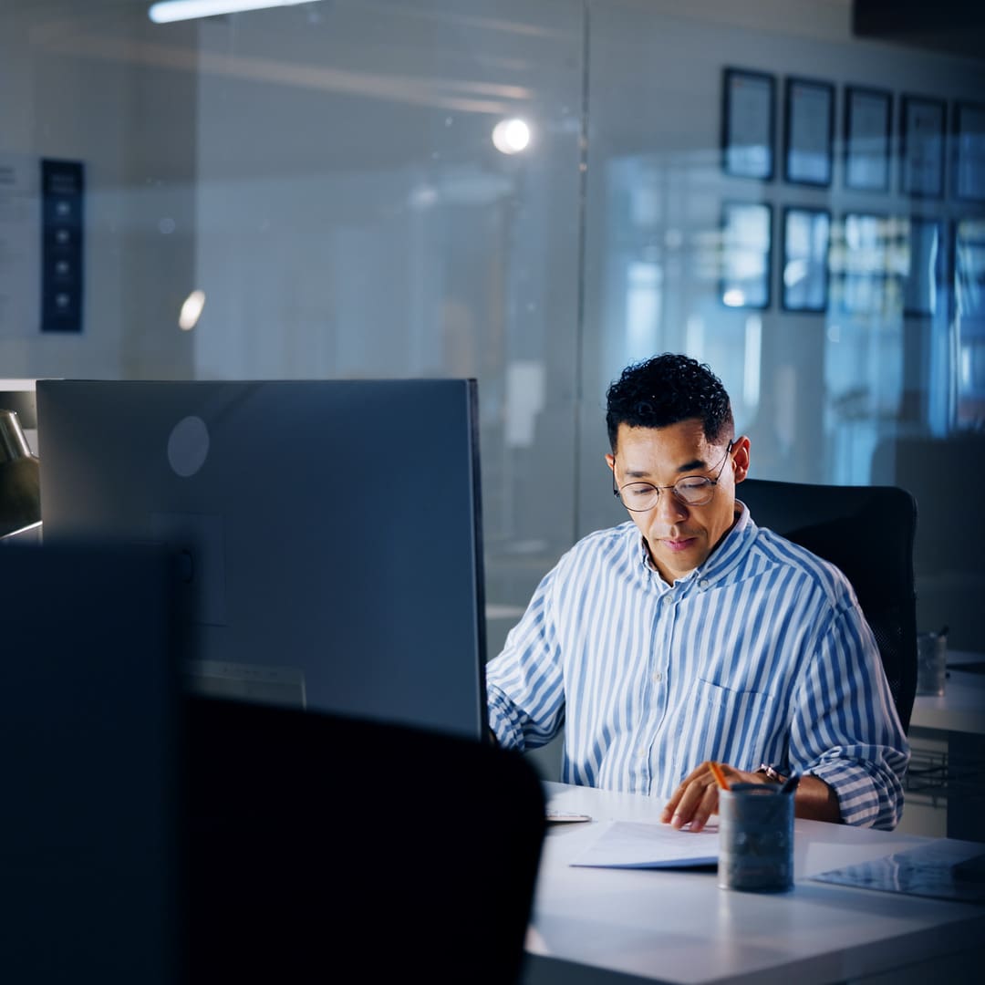 Male IT professional at work desk reviewing documentation