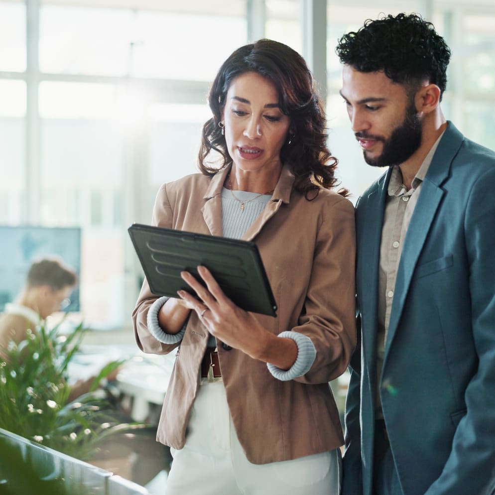 Two cybersecurity and IT analysts reviewing client information